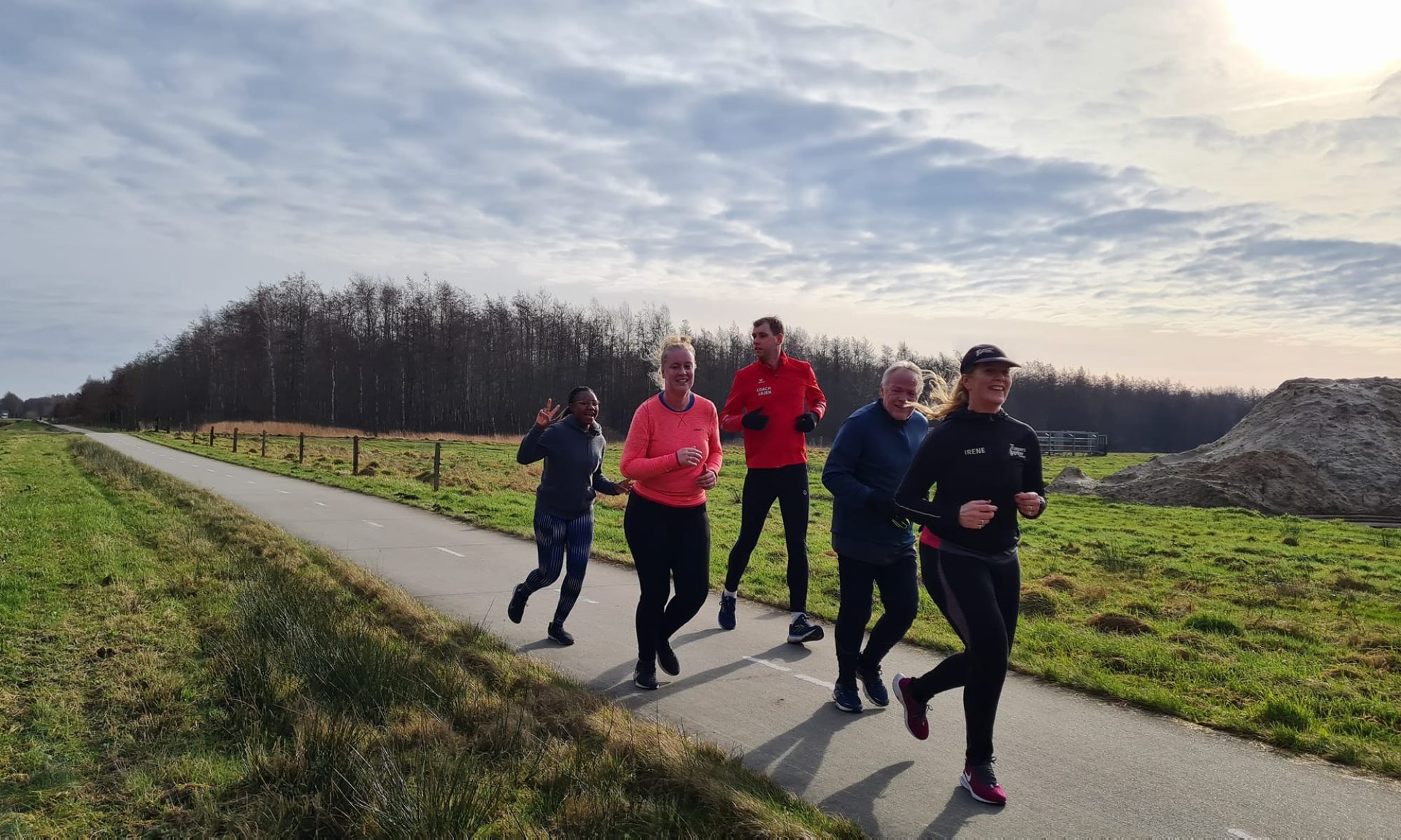 Hardlopers in sportkleding lopen samen over een landelijk pad